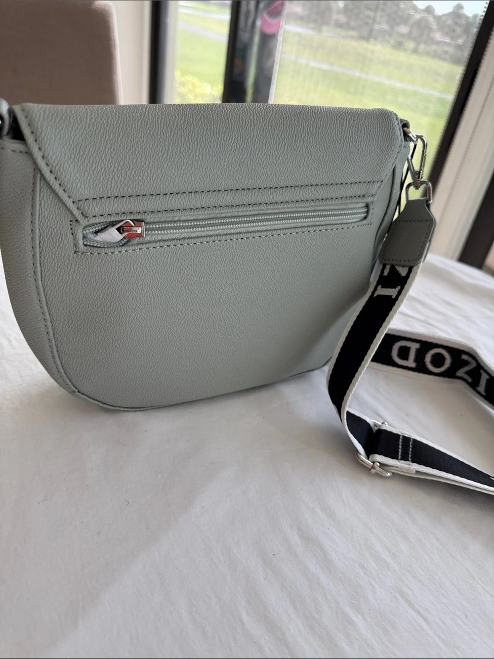 Izod Sage Pebbled Saddle Crossbody with Branded Strap